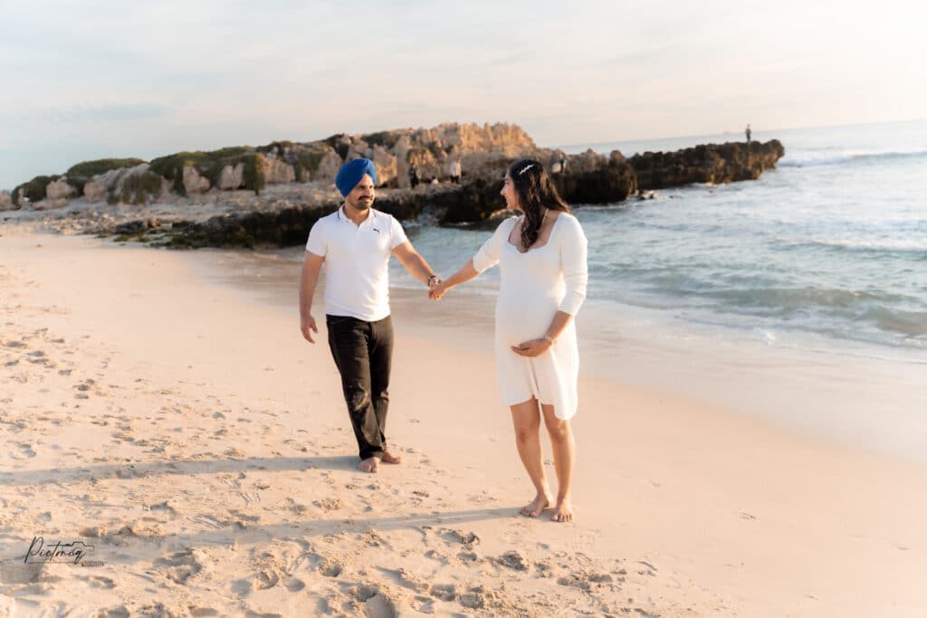 Partner embracing expecting mother, Trigg Beach sunse