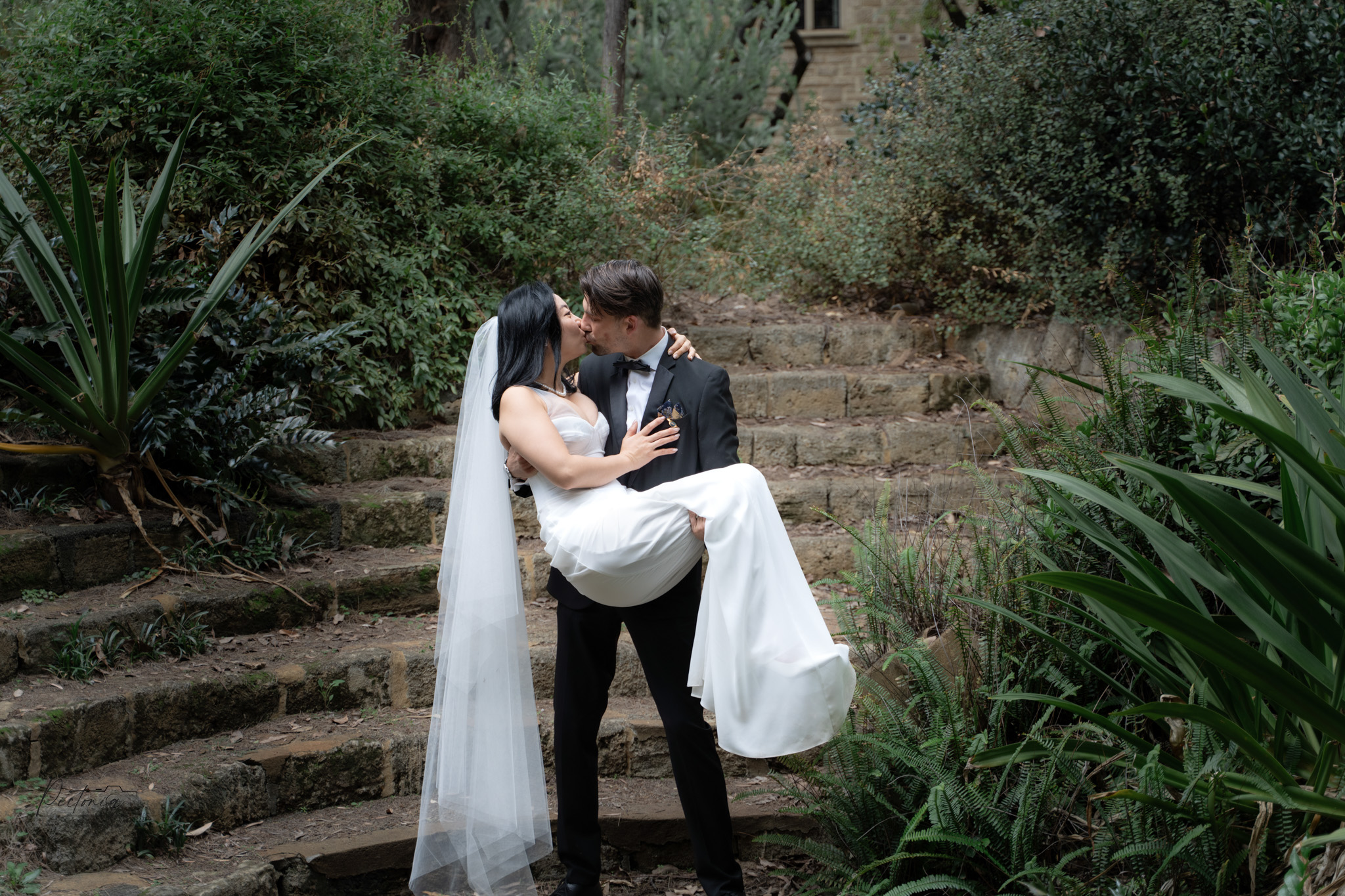 Professional Event Photographer in Perth | a man and woman kissing on stairs
